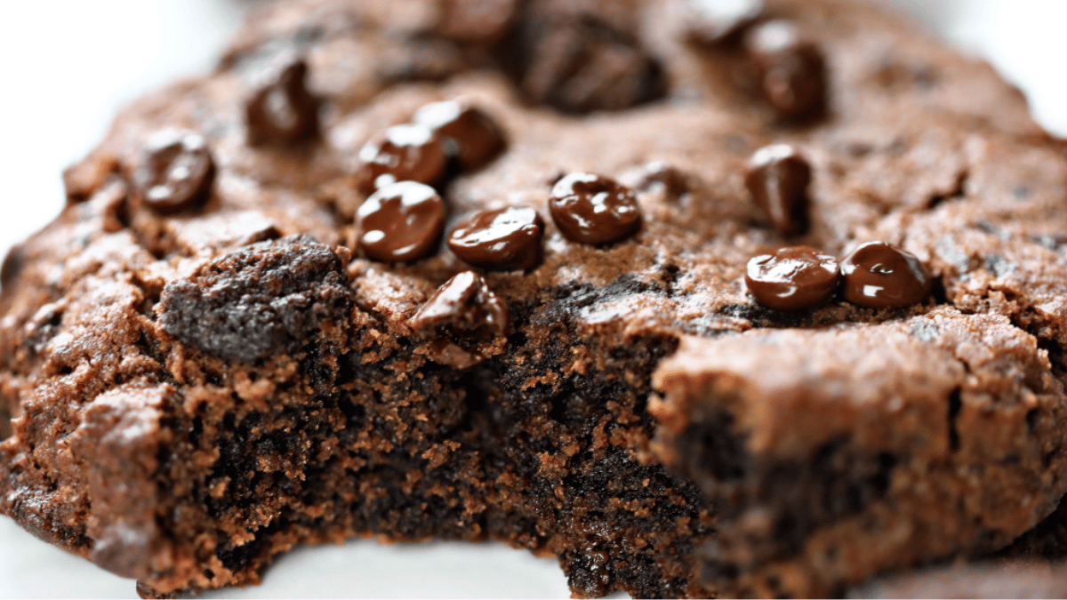 Deliciously fudgy cookie brownies stacked on a plate, topped with a scoop of vanilla ice cream